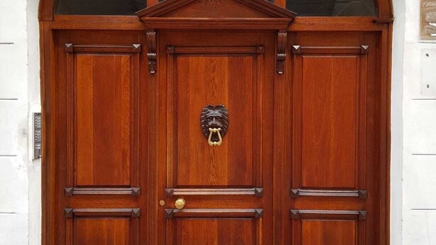 A large wooden double door with a glass transom window above it. - Smart Rooms (Trieste)