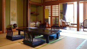 A traditional Japanese room with tatami flooring, a low table, and wooden sliding doors.