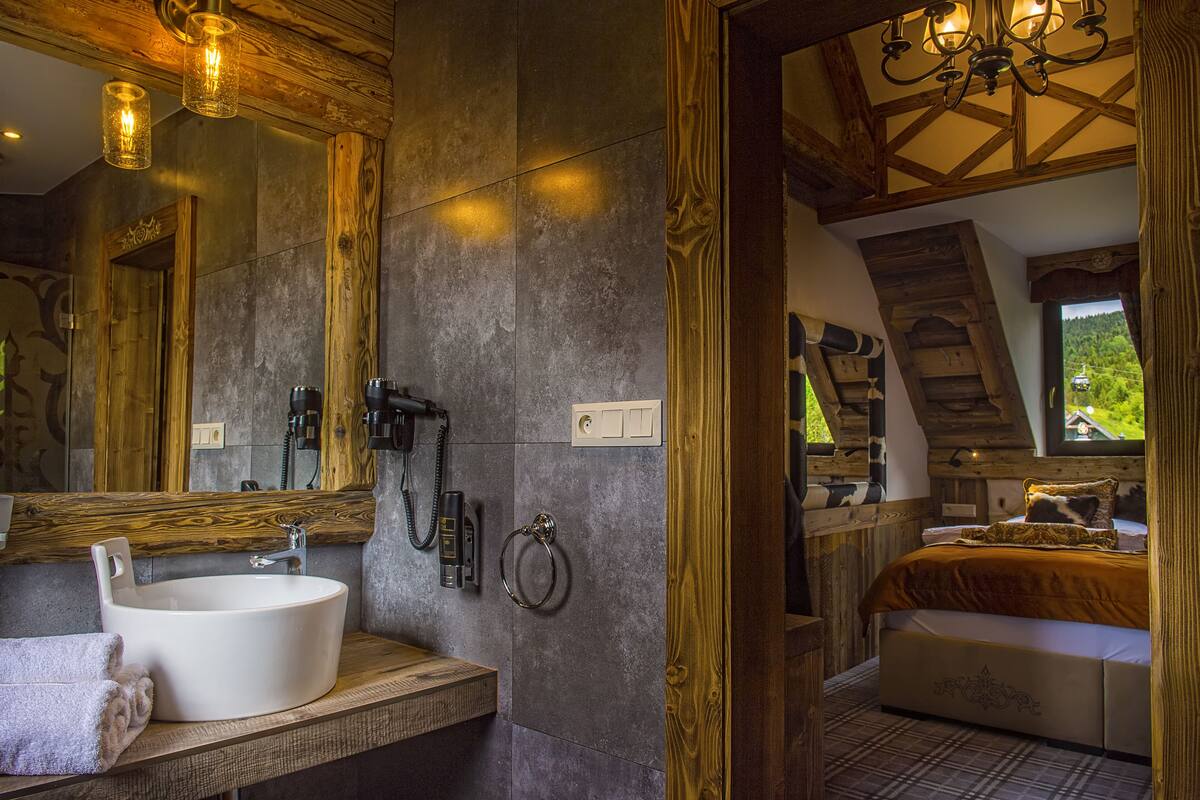 Une salle de bain moderne avec un grand miroir, un lavabo et une serviette.