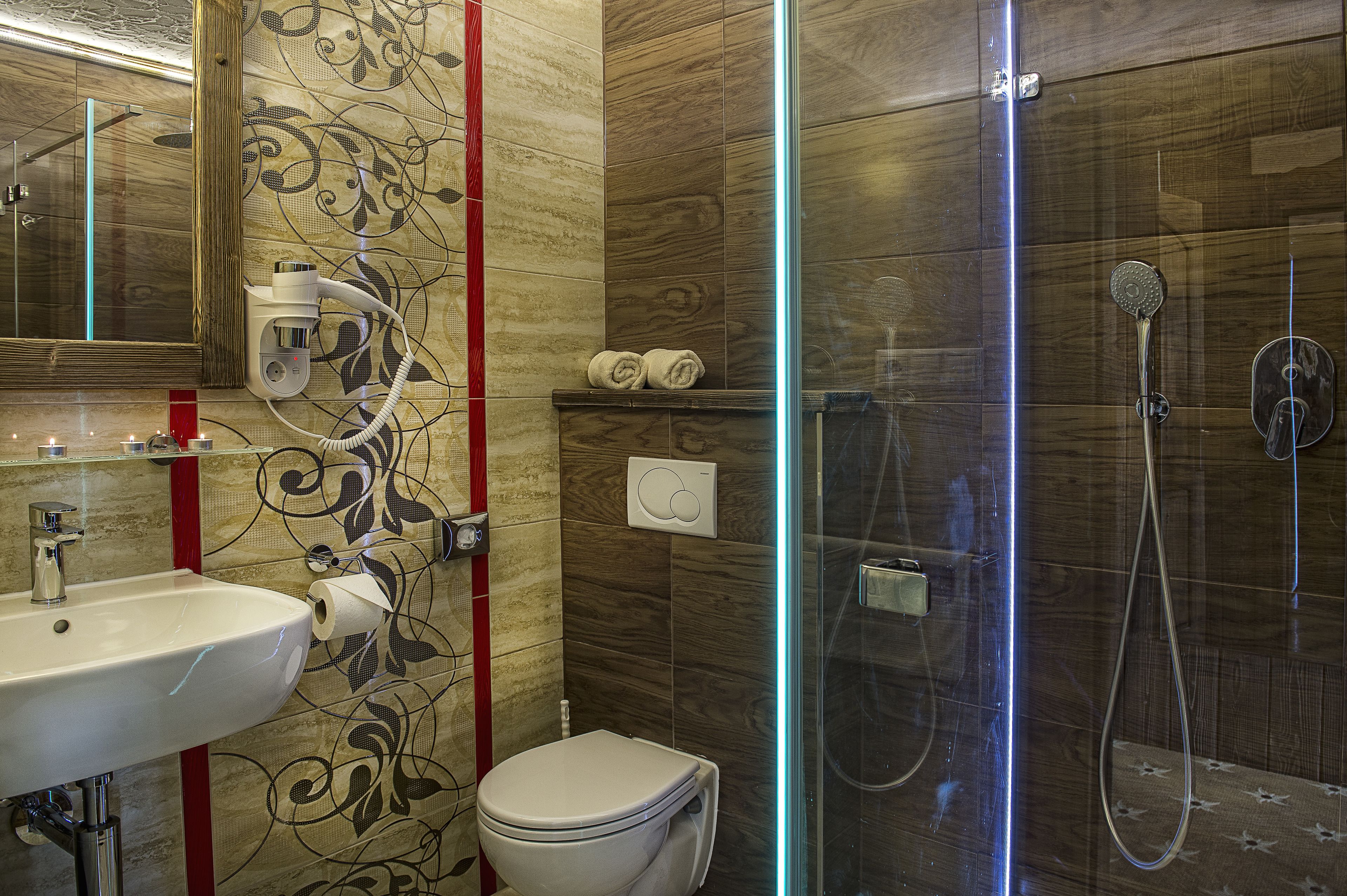 A modern bathroom with a glass-enclosed shower, a white sink, and a toilet.
