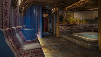 Relax in a serene spa area with a hot tub and mosaic tile design, surrounded by a natural landscape view.