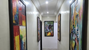 A hallway with multiple framed artworks on the walls and a marble-tiled floor. - Preserve Hotel Lekki Phase 1 (Lekki)