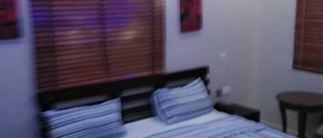 Una camera da letto con un letto, comodini e un tavolino.