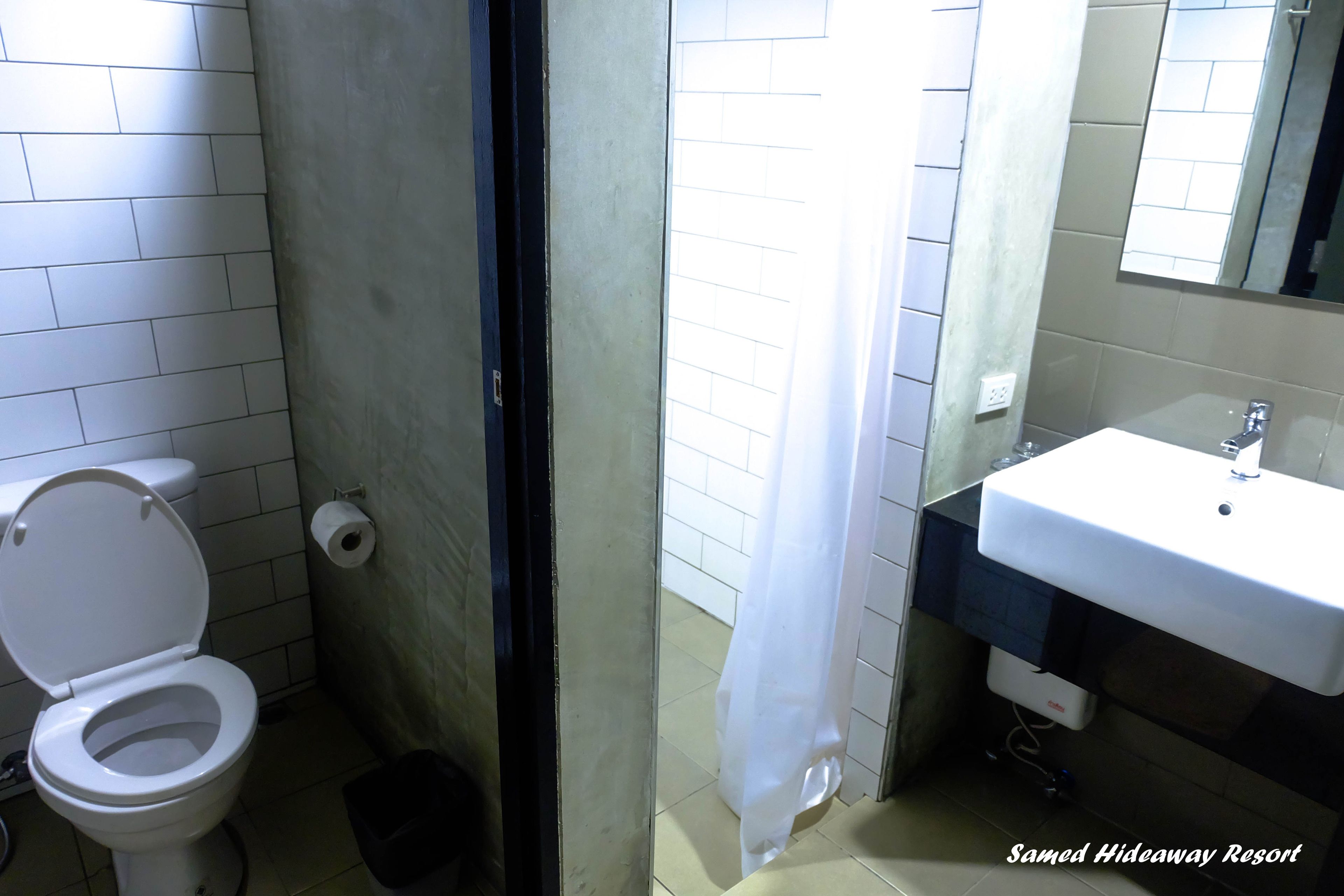 A bathroom with a toilet, sink, and shower curtain.