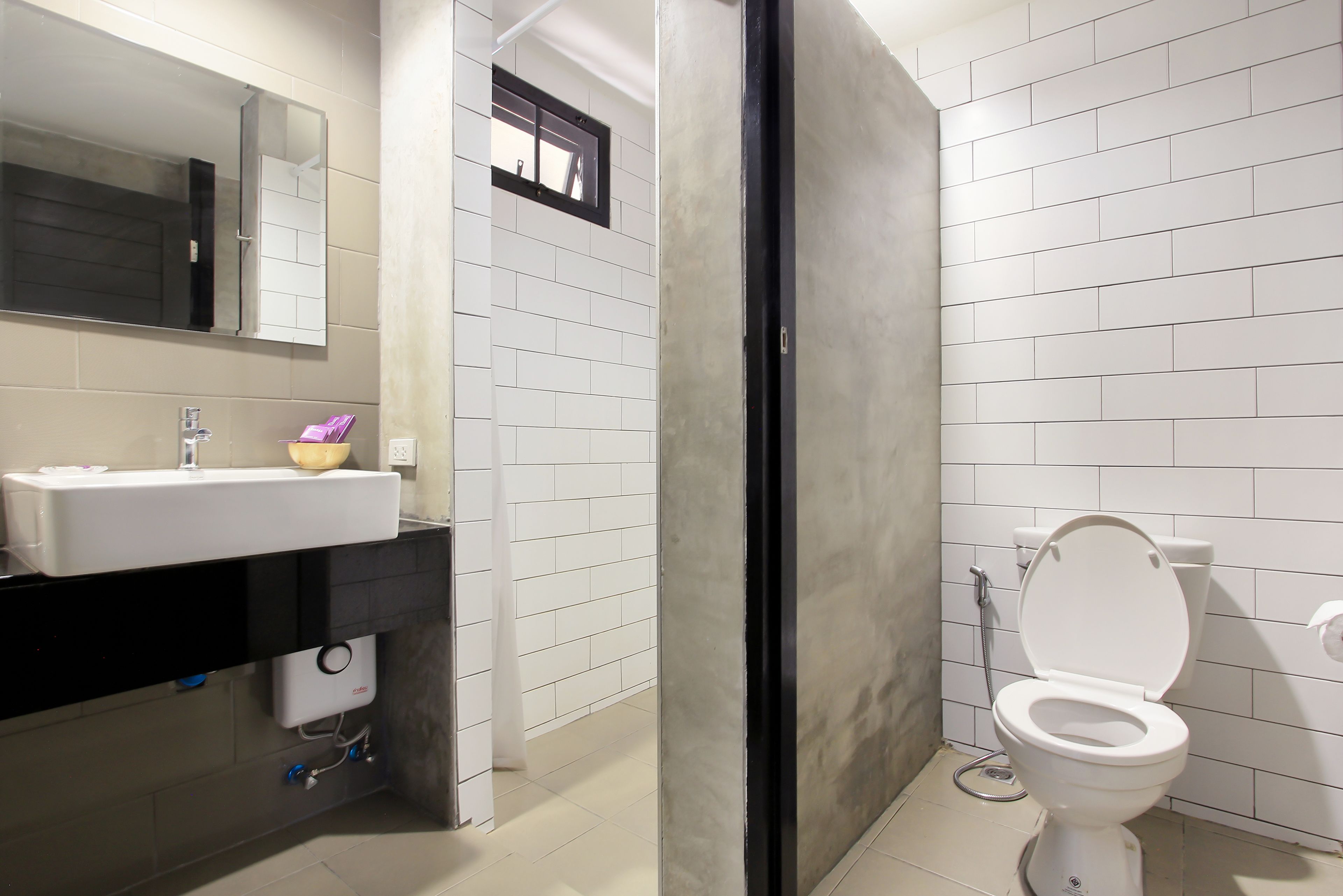 A modern bathroom with a white sink, mirror, and toilet.