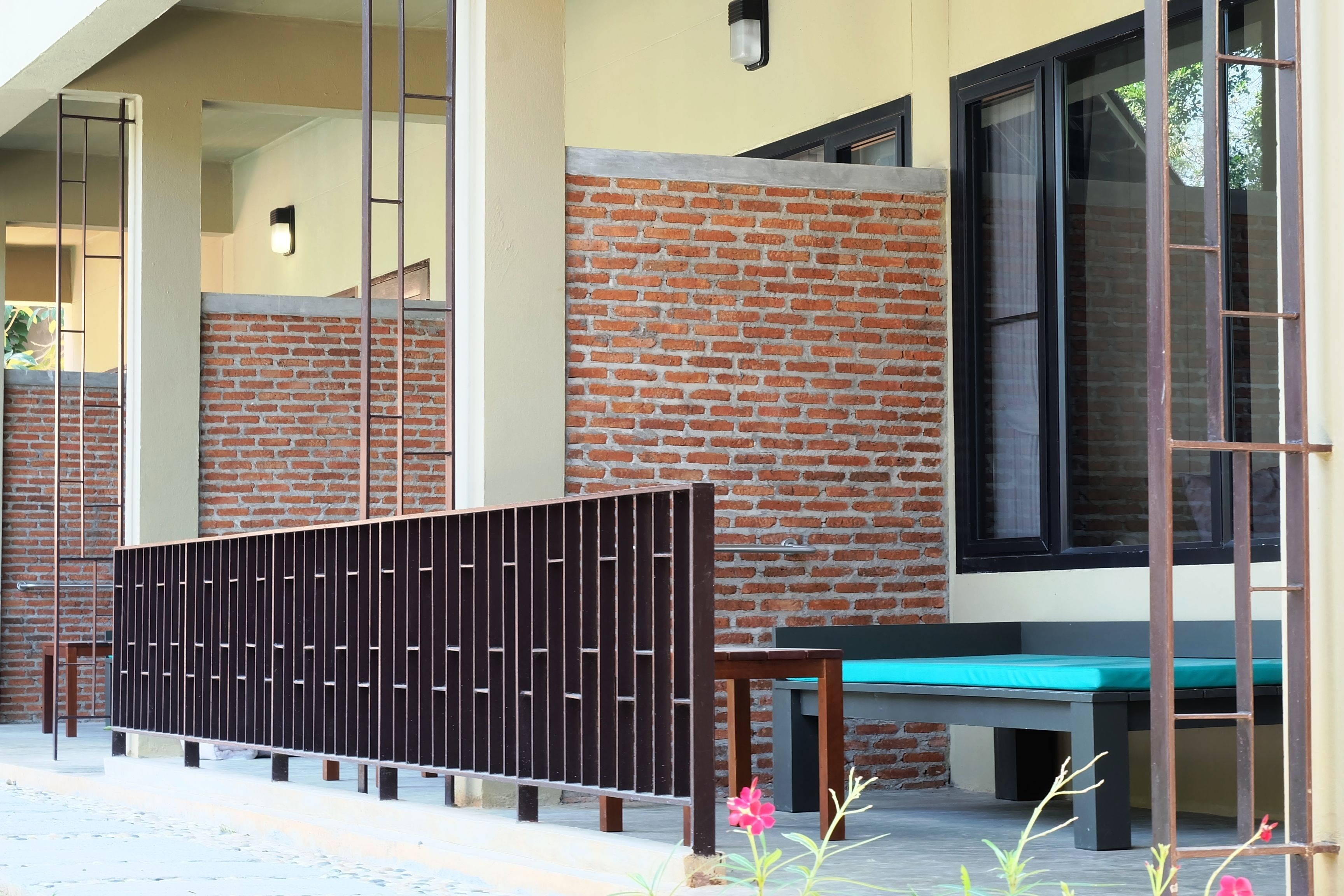A building with a brick facade, large windows, and a bench outside.