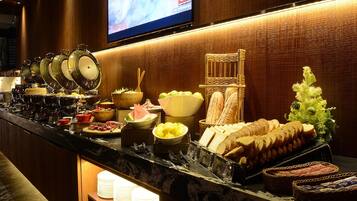 Un bufé con diferentes opciones de comida y una pantalla de televisión que muestra CNN.