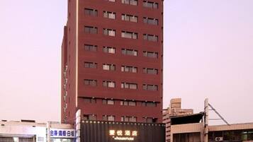 A tall hotel building with multiple floors and a large sign indicating it is a hotel.