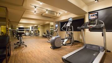 A gym with treadmills, elliptical machines, and weight equipment.