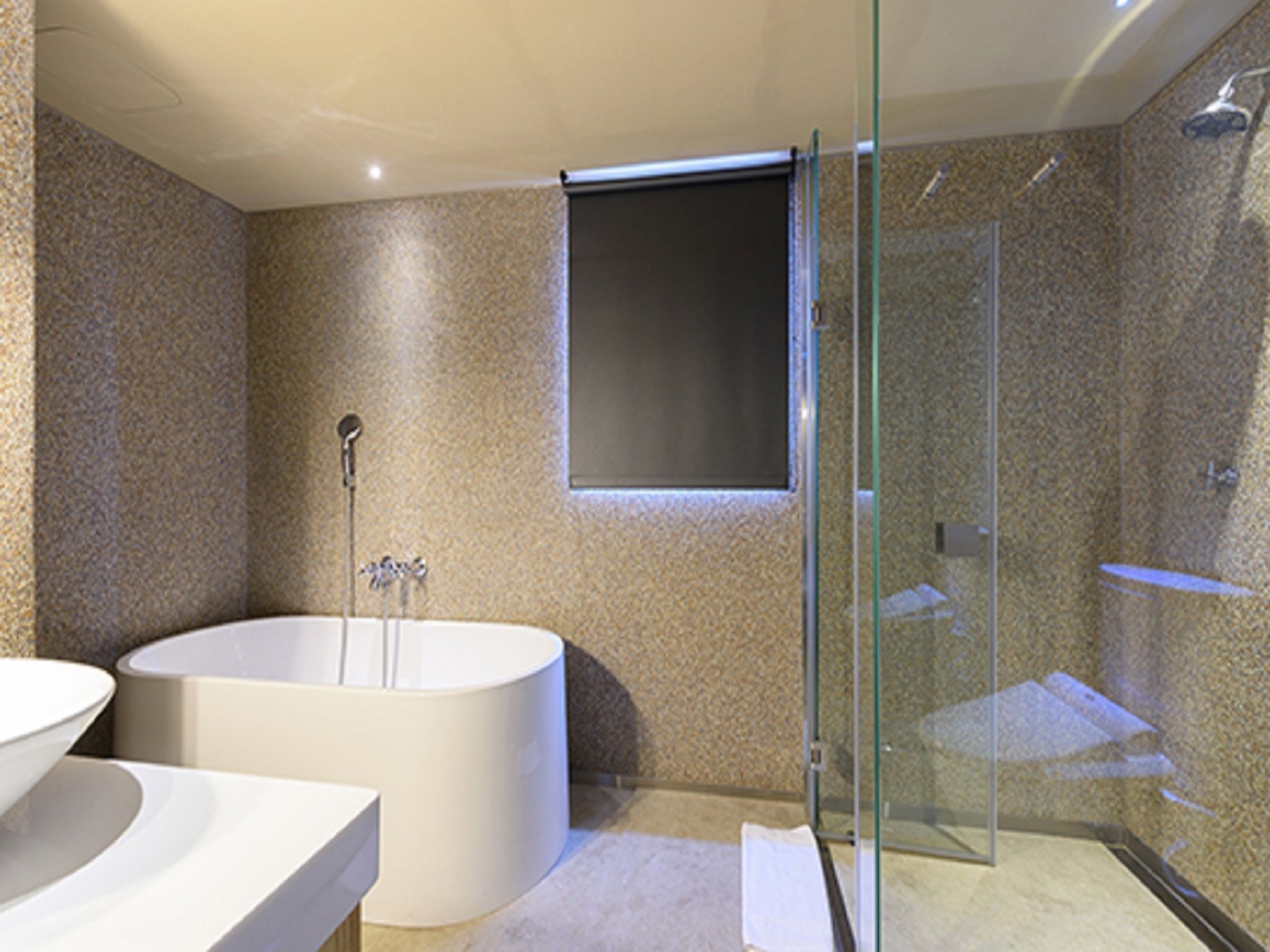 A modern bathroom with a freestanding bathtub, a glass-enclosed shower, and a large mirror.