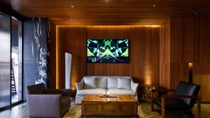Una sala de estar moderna con piso de madera, un sofá, una mesa de centro y un televisor montado en la pared.