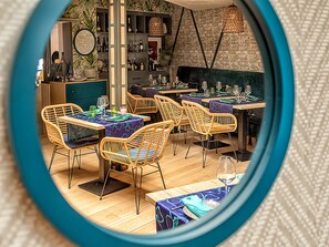 A restaurant with wicker chairs, wooden tables, and a brick wall. - Hostal Real Aranjuez (Aranjuez)