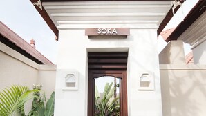 A building entrance with a sign reading "SOKA" above a wooden door. - Villa Puspa (Tabanan)