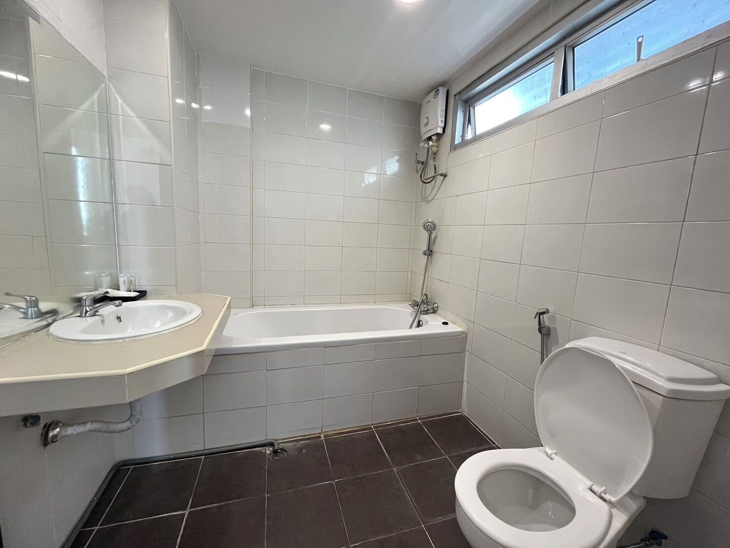 Un baño con lavamanos blanco, bañera y retrete.