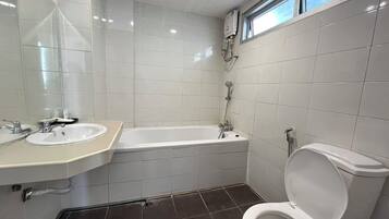 Un baño con lavamanos blanco, bañera y retrete.
