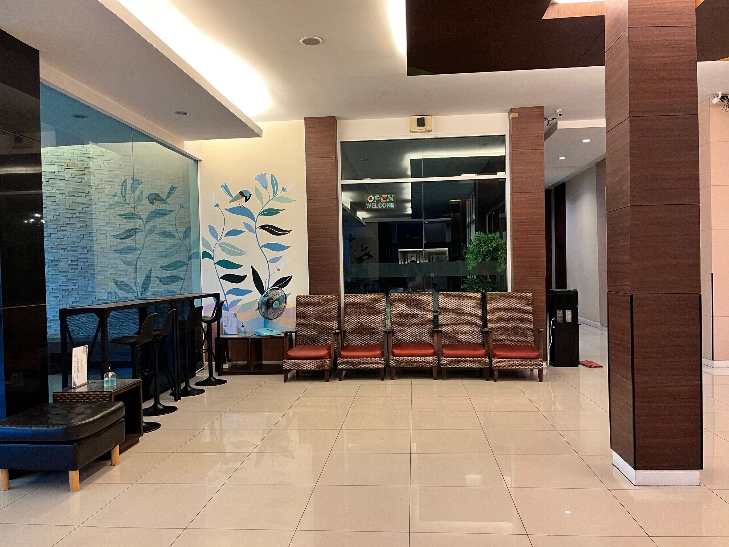 A modern lobby with a reception desk, seating area, and a decorative wall.
