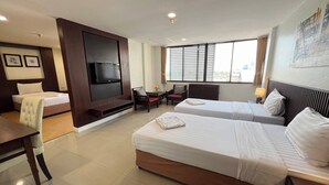 Une chambre d’hôtel avec deux lits, une télévision, un bureau et une chaise.