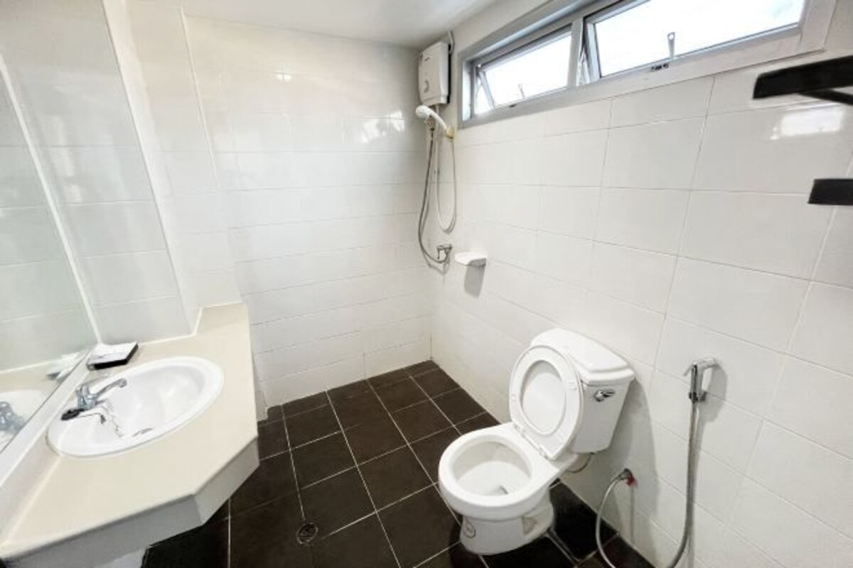 Une salle de bain avec un lavabo blanc, des toilettes et une douche.