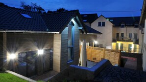 A residential building with a tiled roof, a garage, and a fenced backyard. - Vulkanhotel Balance Selfness (Steffeln)