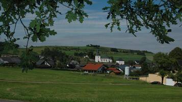 A rural landscape with houses, a church, and a water tower.