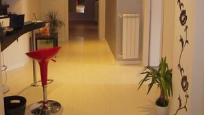 A hallway with a red chair, a potted plant, and a radiator.