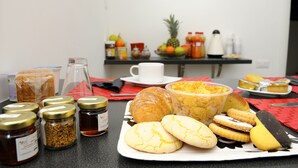 A breakfast table with pastries, bread, and condiments.