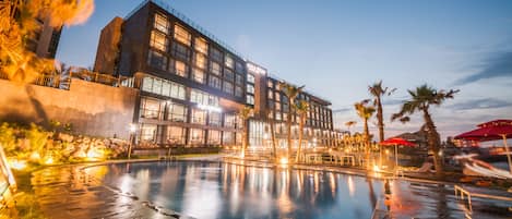 Una piscina al aire libre de temporada, sombrillas