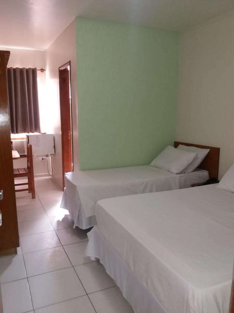 A room with two beds, a desk, and a chair.