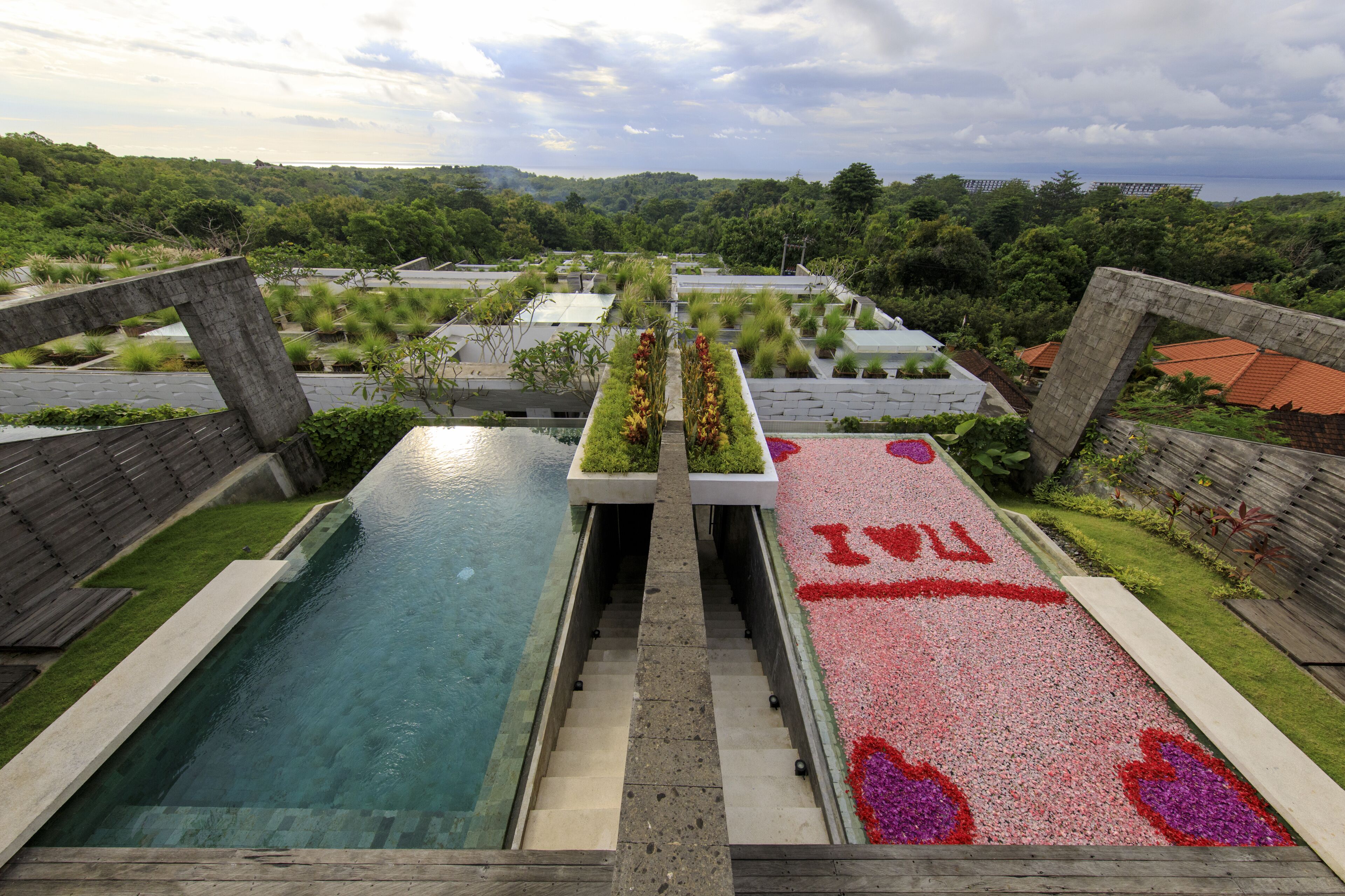 A rooftop pool with a clear view of the surrounding greenery and a distant landscape.