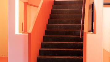 A staircase with a sign reading "GUEST ENTRANCE" leading to a room.