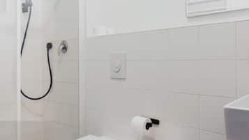 Ein modernes Badezimmer mit Dusche, Toilette, Bidet und Waschbecken.