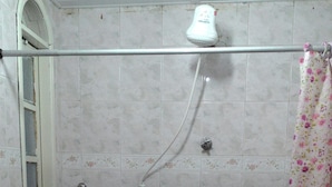 A shower with a floral curtain, a window with a metal frame, and a tiled wall. - Casa Nostra Hospedagem Residencial (Cabo Frio)