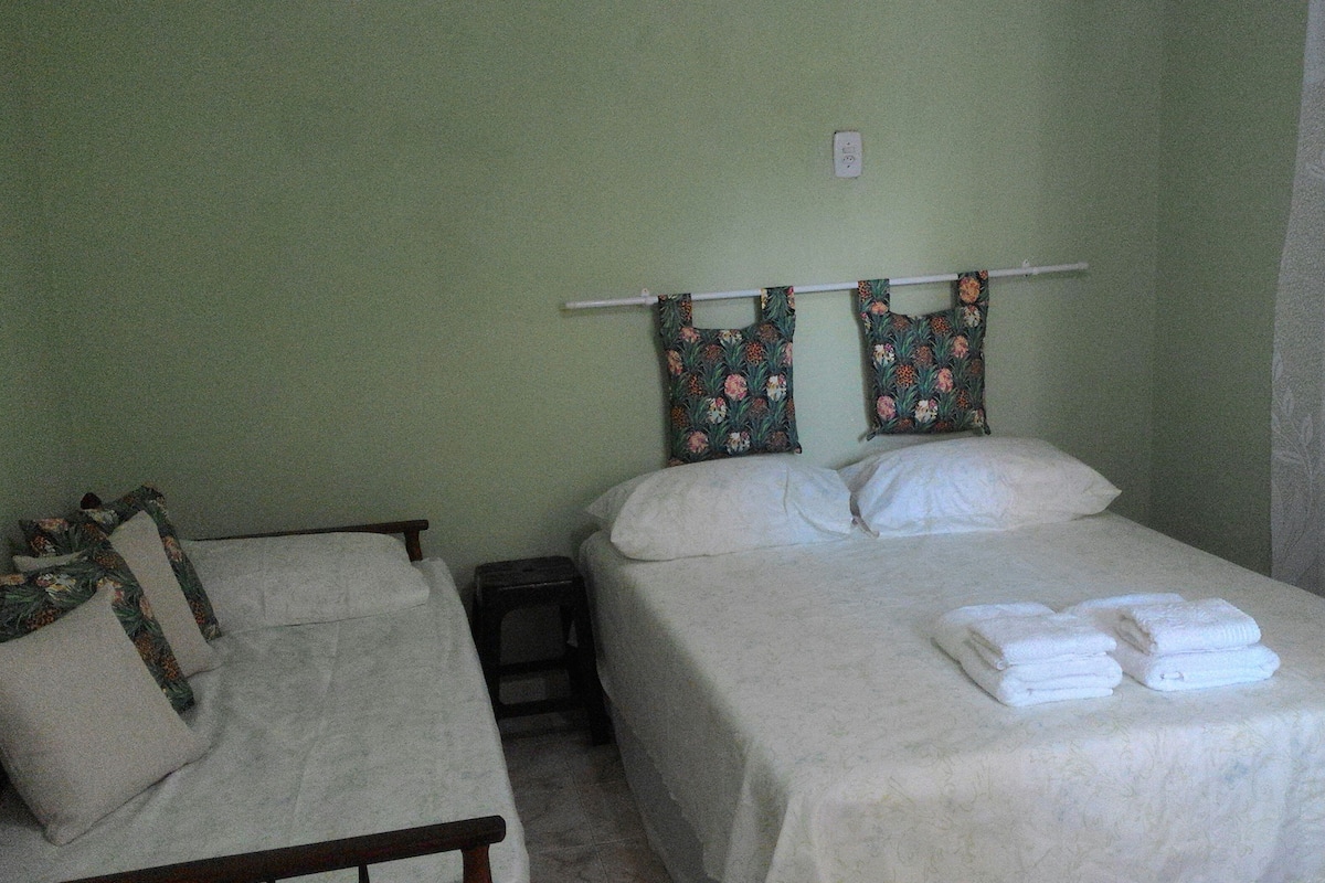 Une chambre avec deux lits, une petite table et une chaise.