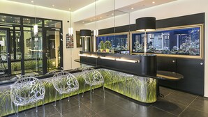 Un área de recepción moderna con un mostrador curvo, sillas transparentes y una gran vitrina con peces.