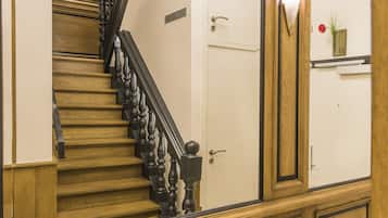A wooden staircase with black balusters and a white door at the top.