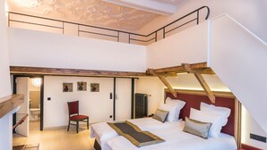 Un dormitorio con una cama grande, una silla y una escalera.