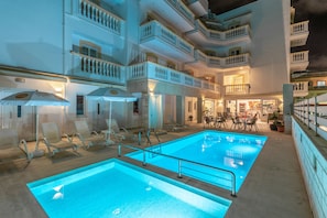A hotel with a pool area, sun loungers, and a bar/lounge area. - Irini Apartments (Hersonissos)