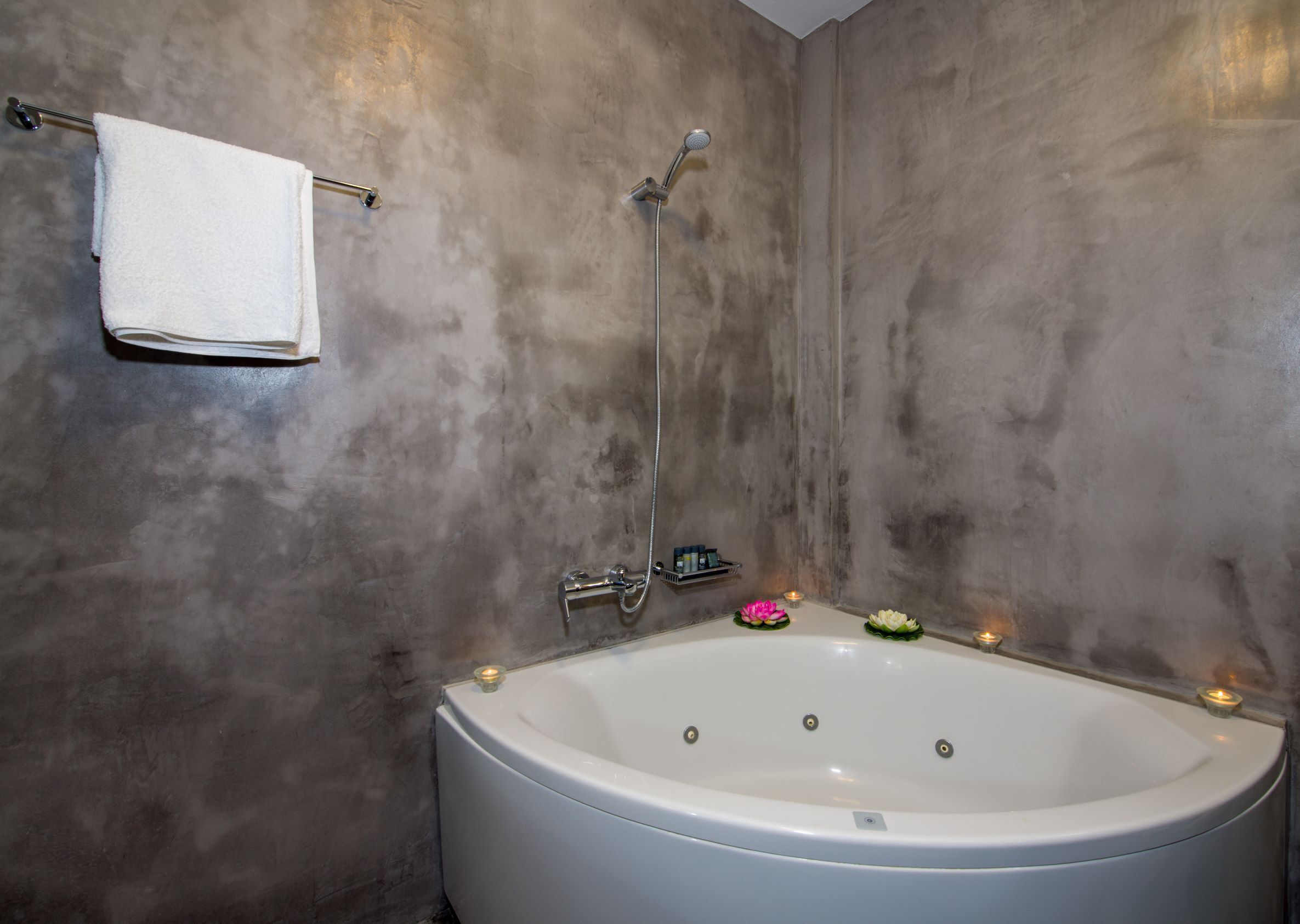 Ein modernes Badezimmer mit einer freistehenden Badewanne, einer Handbrause und einem Handtuchhalter.