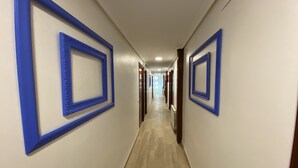 Un pasillo con decoraciones enmarcadas en azul y suelo de madera.