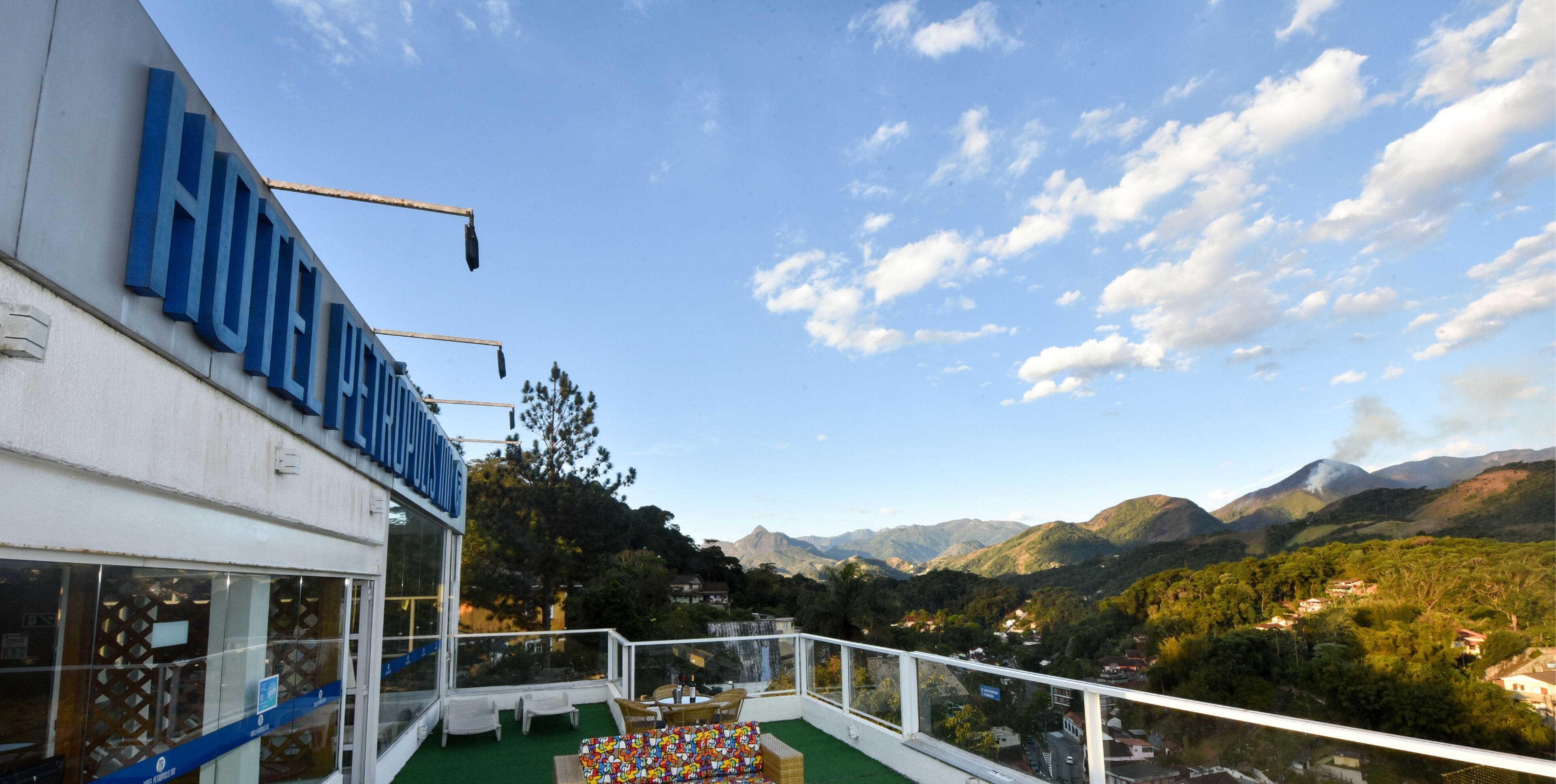 Un hotel llamado "HOTEL LUIS" con vistas a montañas y vegetación.