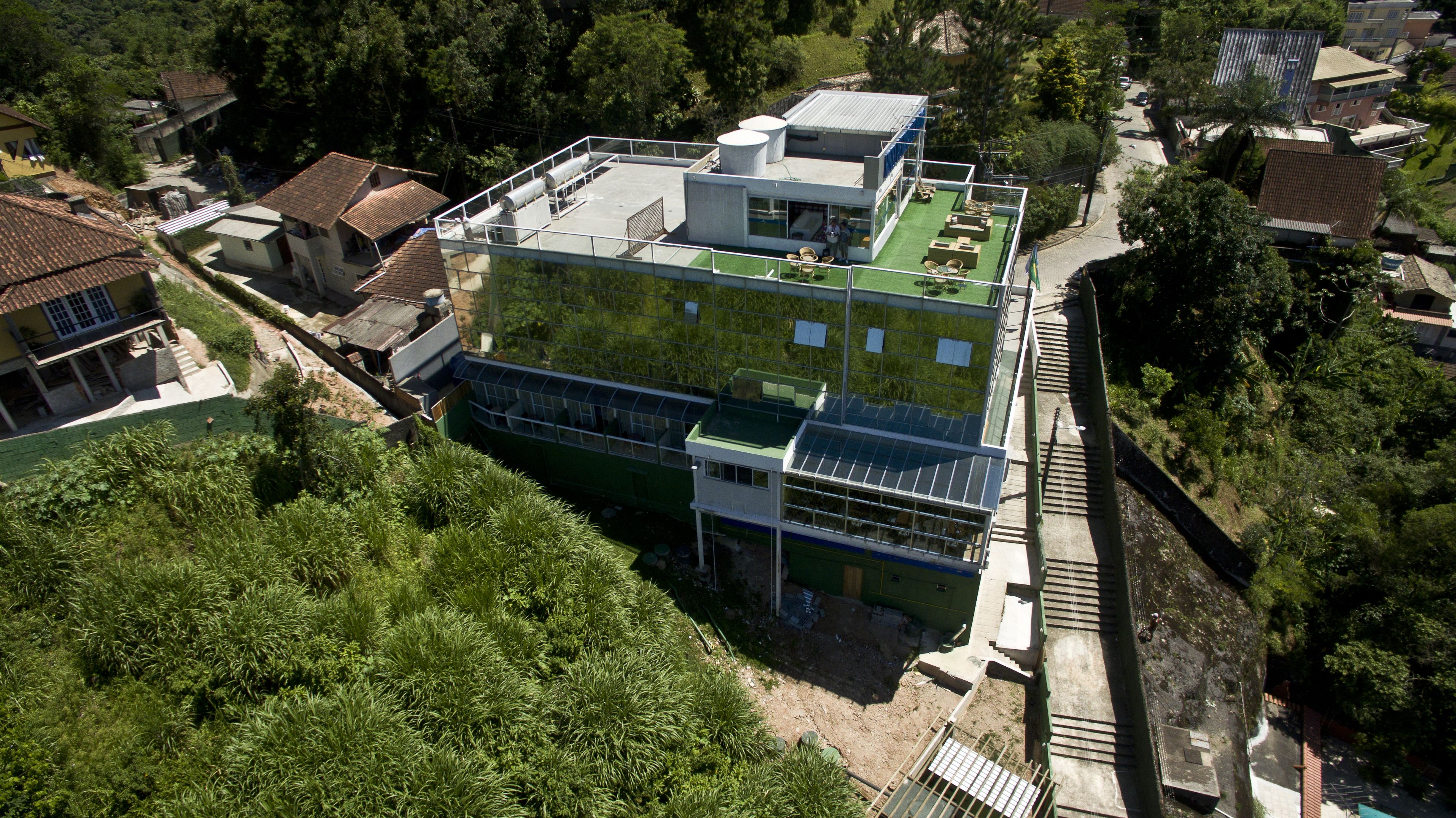A modern building with a flat roof, large windows, and a green rooftop garden.