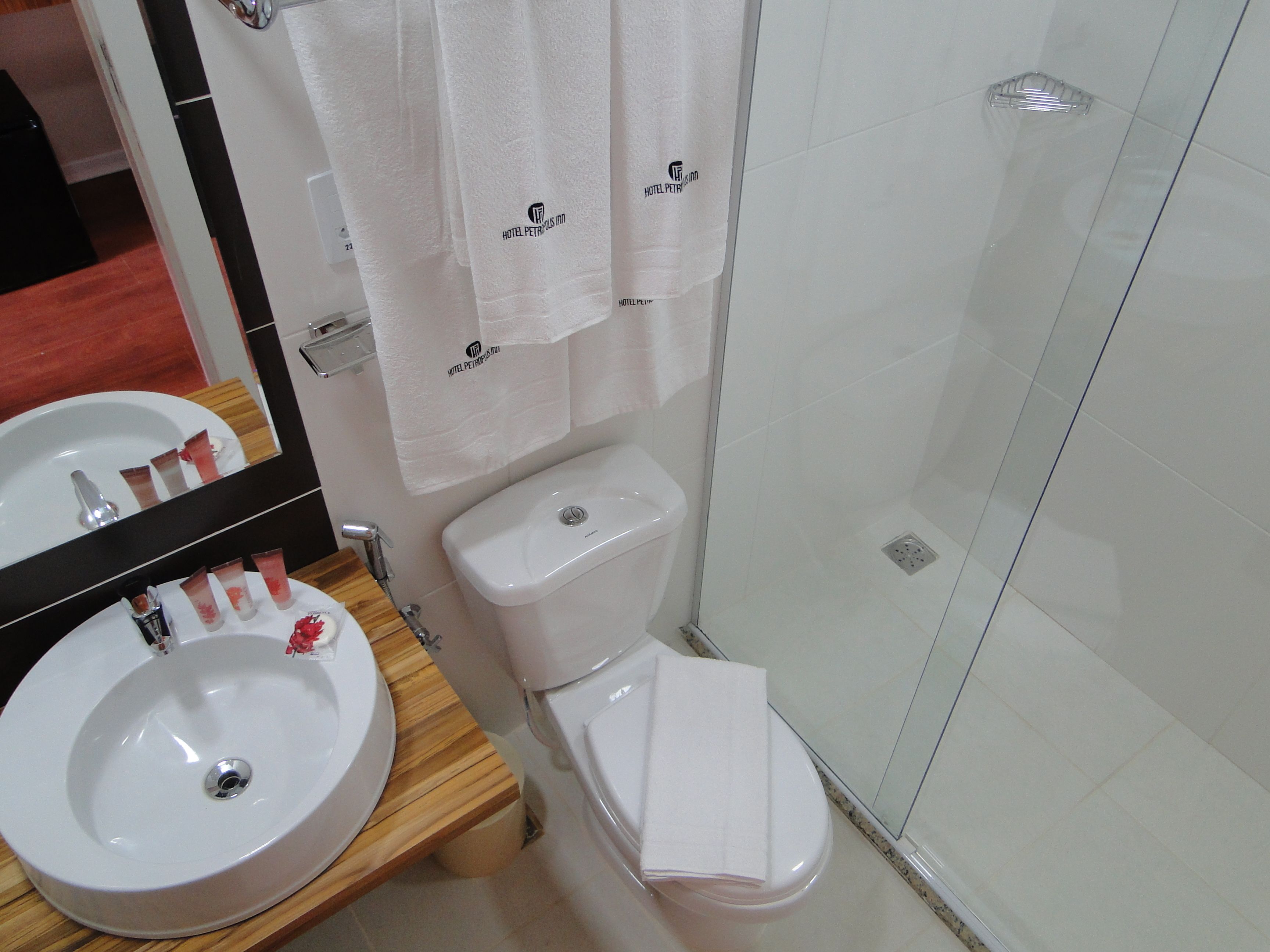 A bathroom with a sink, toilet, and glass shower enclosure.