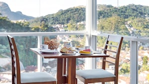Una mesa de comedor con sillas y vistas a una colina.