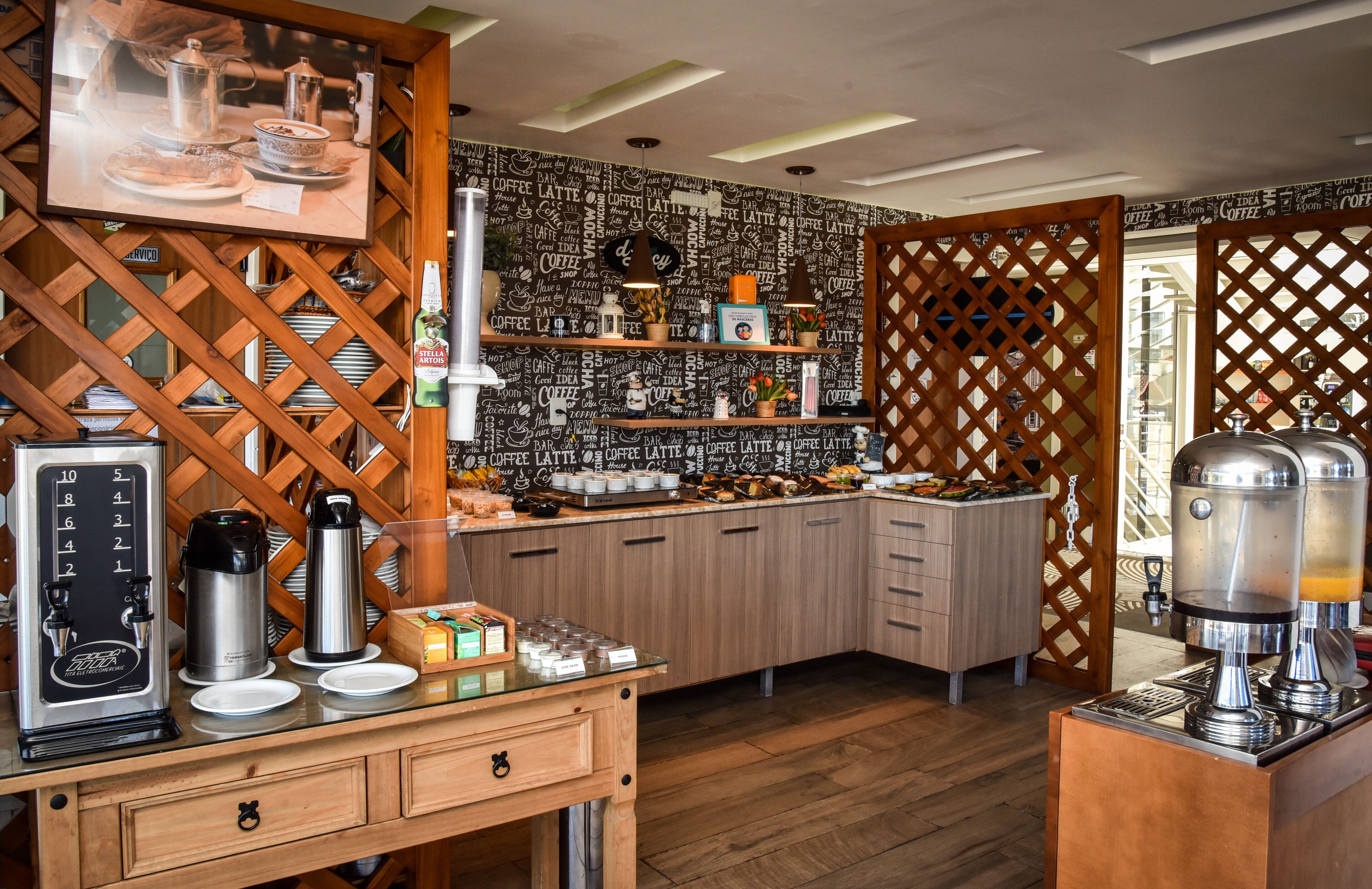 Una estación de café con varias cafeteras, un dispensador de café y una variedad de tazas y pasteles.