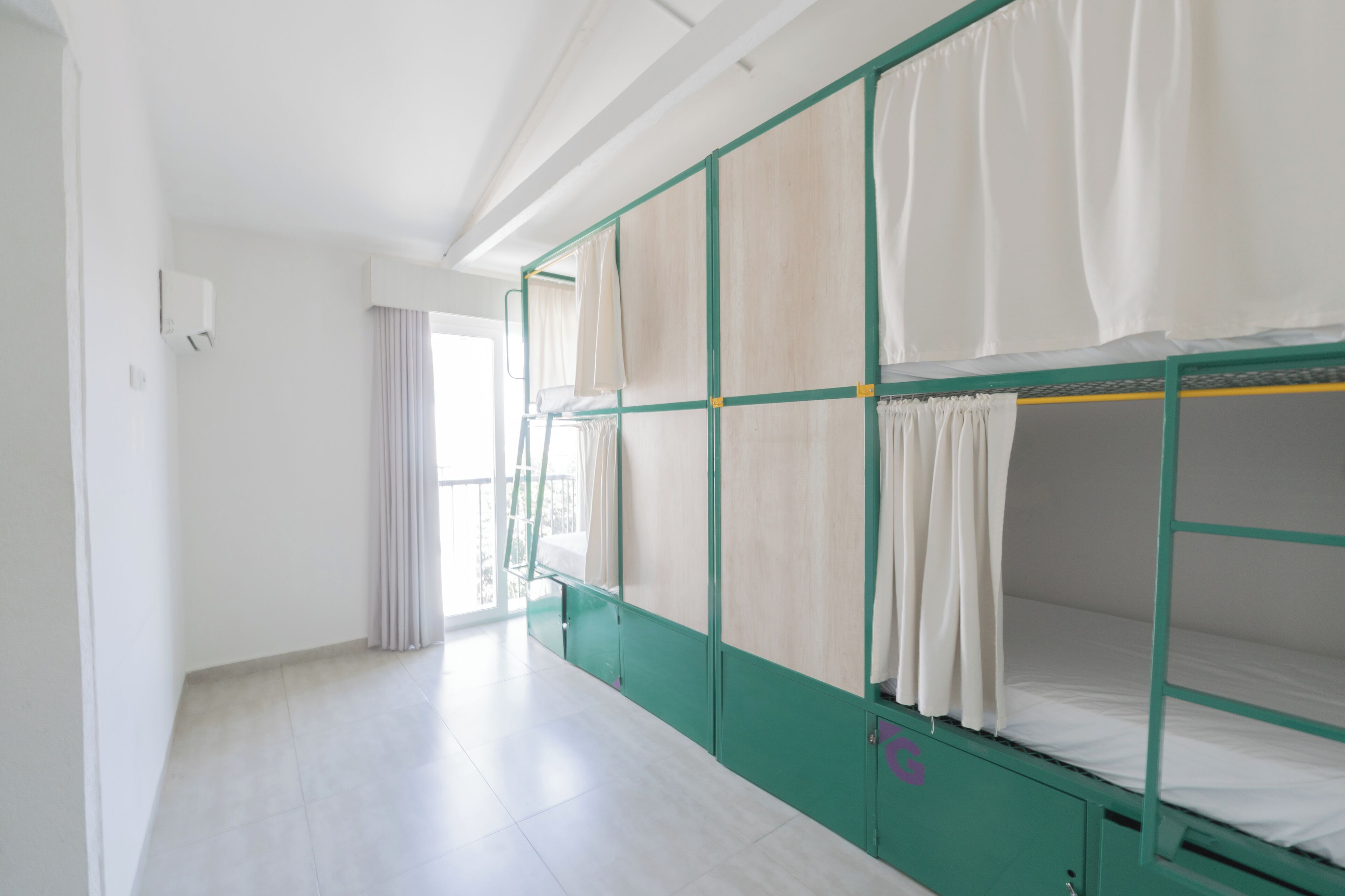 A room with bunk beds, a window with curtains, and a tiled floor.