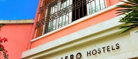 A building with a sign reading "VIAJERO HOSTELS".