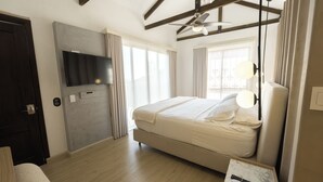 A modern hotel room with a large bed, a flat-screen TV mounted on the wall, a ceiling fan, and a small table with a remote control. - Viajero Cali Hostel & Salsa School (Cali)
