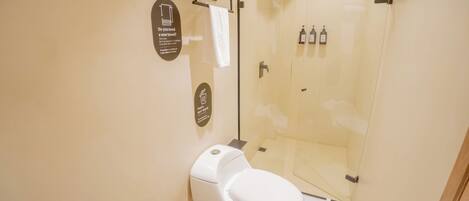 A modern bathroom with a toilet, a glass shower enclosure, and a towel rack.