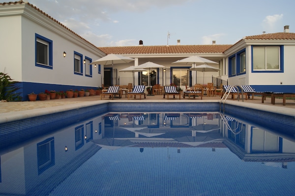 Una piscina al aire libre de temporada, sombrillas