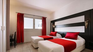 A hotel room with two beds, red curtains, a window, and a tiled floor. - Anezi Apartments (Agadir)